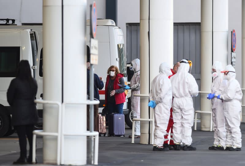 Passengers from the the Costa Luminosa cruise ship that was hit by the coronavirus disease (COVID-19) are led from a ship to buses, at the port of Savona, near Genoa