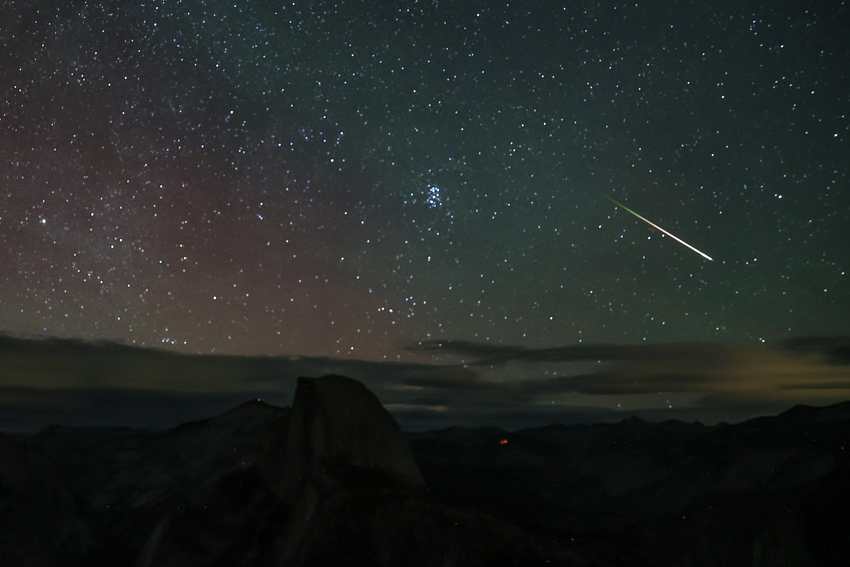 Un meteor trece cu viteză pe cerul înstelat lângă Glacier Point din Parcul Național Yosemite.