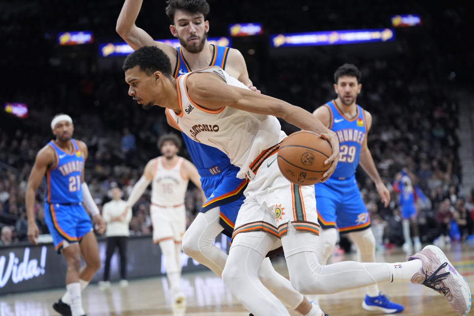 San Antonio Spurs center Victor Wembanyama (1) drives around Oklahoma City Thunder forward Chet Holmgren, rear, during the first half of an NBA basketball game in San Antonio, Wednesday, Jan. 24, 2024. (AP Photo/Eric Gay)