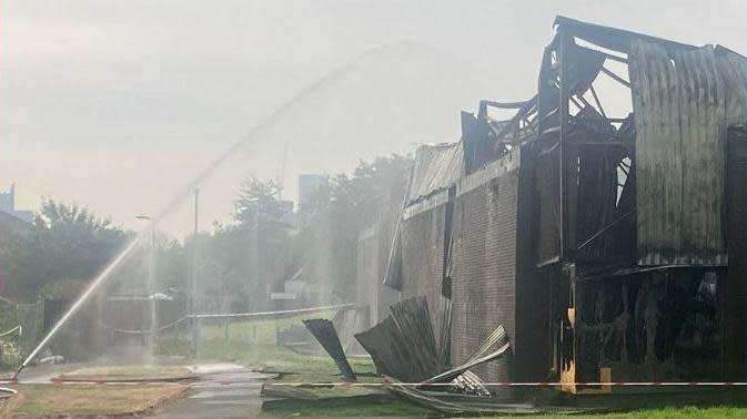 water being sprayed over smoking ruins