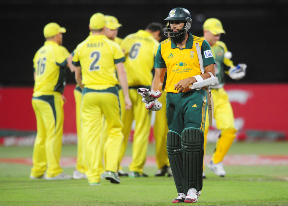 In this photo taken Wednesday, March 12, 2014, South Africa's Hashim Amla leaves the field after being dismissed for four runs during their rain-delayed T20 cricket match against Australia in Durban, South Africa. (AP Photo)