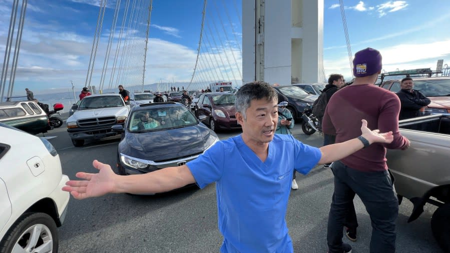 Dr. George Tanaka walks through the Bay Bridge blockade. (AP Photo/Noah Berger)