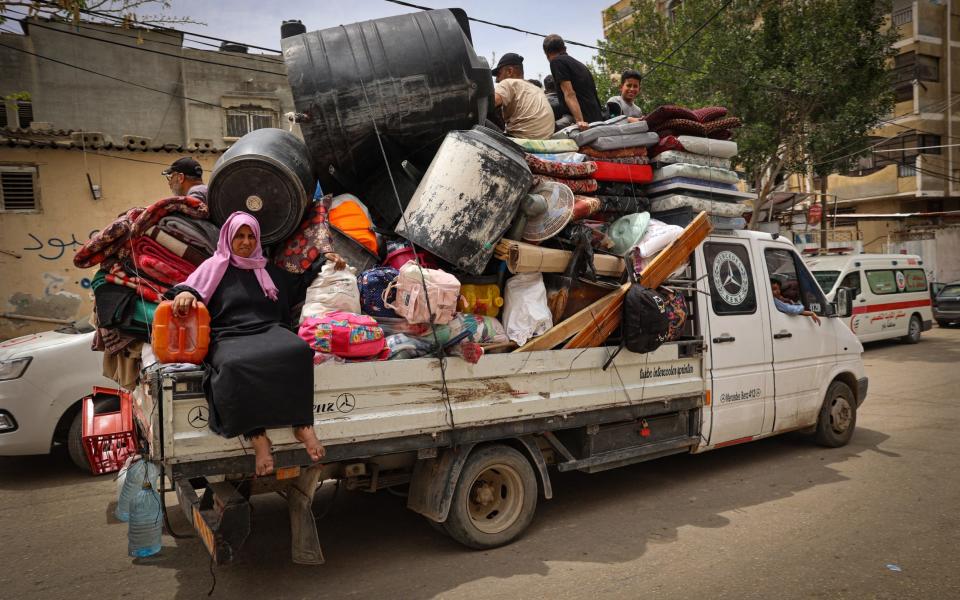 Palestinians pile their belongings on a vehicle as it drives to safer areas in Rafah, in the southern Gaza Strip, on May 10, 2024