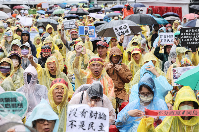 立法院28日續審國會改革法案，許多民眾不畏雨勢穿雨衣在立法院外圍集結，現場高喊口號，盼讓立法院聽到人民聲音。（中央社）