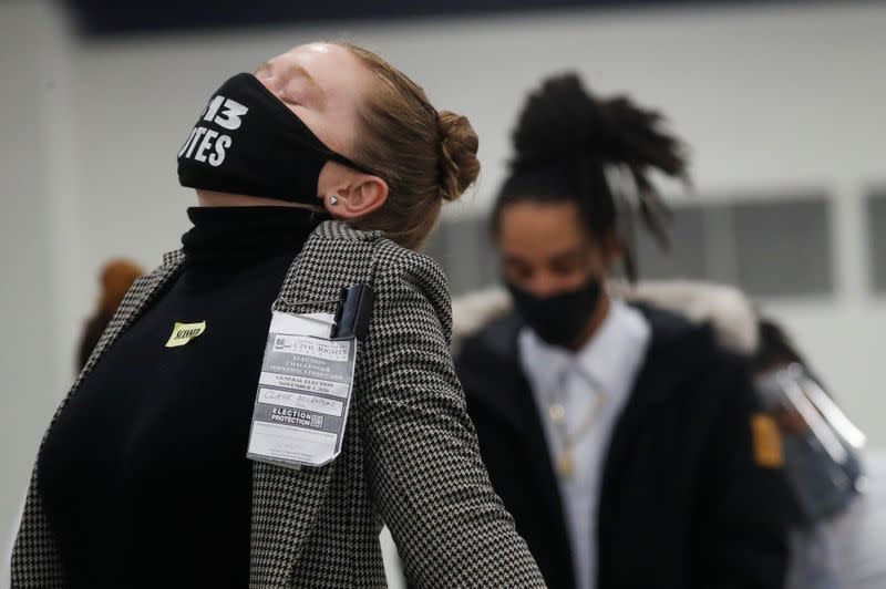 An election challenger stretches as votes continue to be counted at the TCF Center the day after the 2020 U.S. presidential election, in Detroit, Michigan