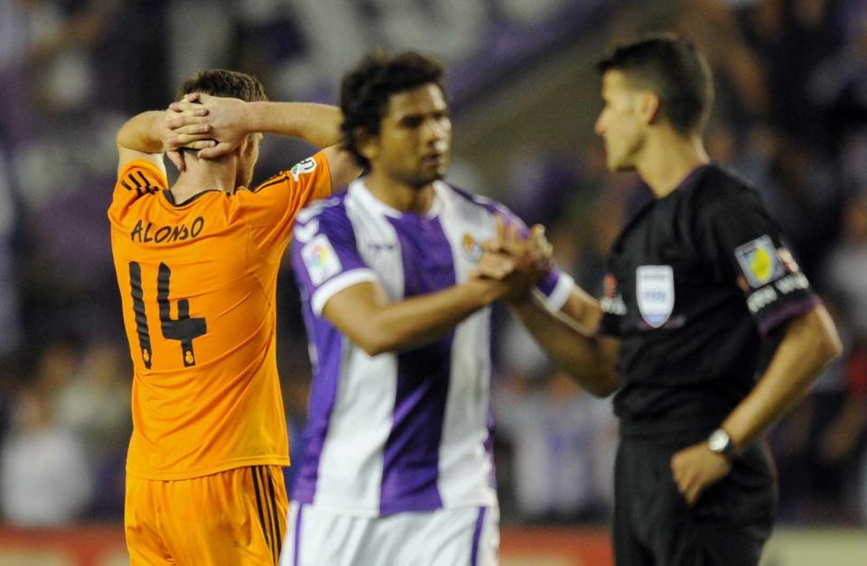 Real Madrid's midfielder Xabi Alonso, left gestures, as Real Valladolid's Colombian forward Humberto Osorioduring talks to the referee, during a Spanish La Liga soccer match at the Jose Zorrilla stadium in Valladolid, Spain, Wednesday, May 7, 2014. (AP Photo/Israel L. Murillo)