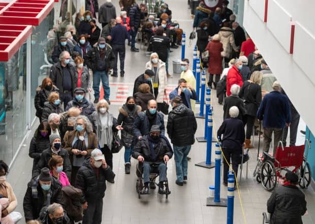 Crowds of people waited for their COVID-19 vaccinations at the Olympic Stadium in Montreal on Monday. It was one of about 15 sites that are now open to the public in the city.