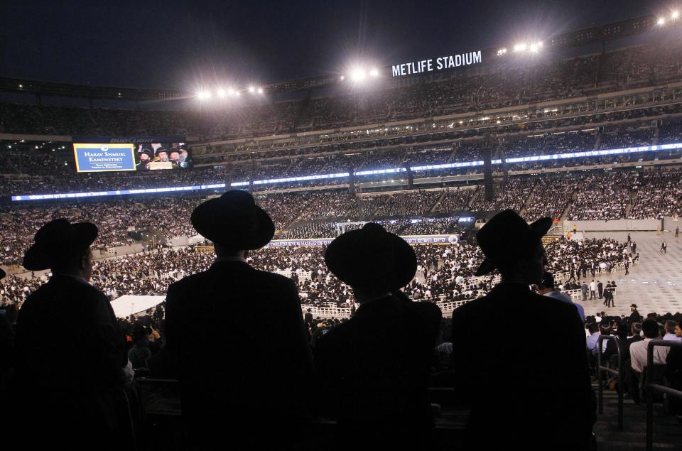 A large crowd of Orthodox Jewish men stand at MetLife stadium in East Rutherford, N.J, Wednesday, Aug. 1, 2012, during the celebration Siyum HaShas. The Siyum HaShas, marks the completion of the Daf Yomi, or daily reading and study of one page of the 2,711 page book. The cycle takes about 7½ years to finish.This is the 12th put on my Agudath Israel of America, an Orthodox Jewish organization based in New York. Organizers say this year's will be, by far, the largest one yet. More than 90,000 tickets have been sold, and faithful will gather at about 100 locations worldwide to watch the celebration. (AP Photo/Mel Evans)