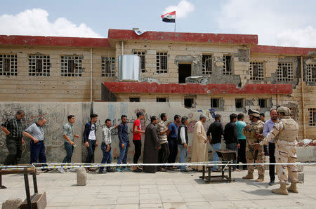 Iraqi people stand in a queue to cast their vote at a polling station during the parliamentary election in Mosul, Iraq May 12, 2018. REUTERS/Khalid al-Mousily