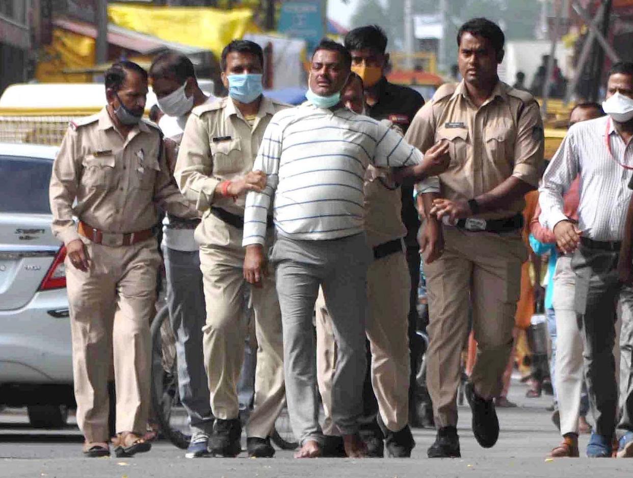 Suspected crime boss Vikas Dubey is pictured after handing himself in to Madhya Pradesh police on Thursday. Less than 24 hours later he was shot dead: EPA