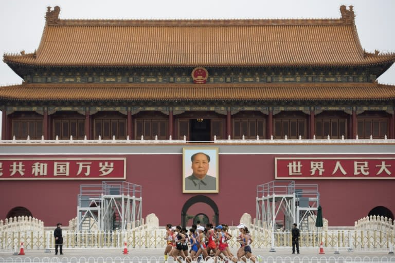 Athletes run past a portrait of Mao Zedong in Tiananmen Square as they compete in the final of the women's marathon athletics event at the 2015 IAAF World Championships in Beijing on August 30, 2015