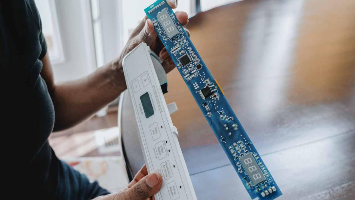 Woman replacing refrigerator's user interface