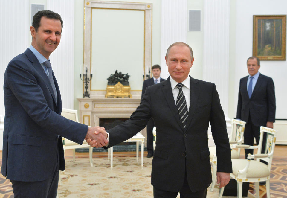 FILE - Russian President Vladimir Putin shakes hands with Syrian President Bashar Assad as Russian Foreign Minister Sergey Lavrov looks on, in Moscow, Oct. 20, 2015. The meeting at the Kremlin occurred less than a month after Russia began airstrikes in Syria that Putin called necessary to destroy terrorist groups. The action helped Syrian President Bashar Assad, a longtime ally, remain in power. (Alexei Druzhinin/Moscow News Agency via AP, Pool, File)