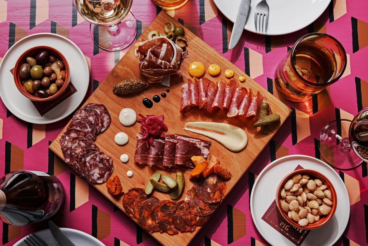 Iberian Pig serves charcuterie boards with meats and cheeses and garnishes.