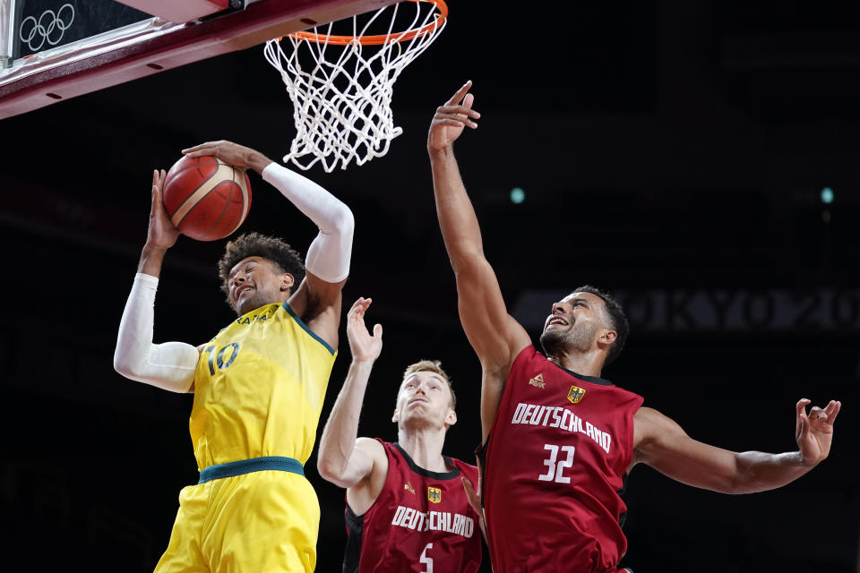 Australia's Matisse Thybulle (10) grabs a rebound in front of Germany's Johannes Thiemann (32) during a men's basketball preliminary round game at the 2020 Summer Olympics, Saturday, July 31, 2021, in Saitama, Japan. (AP Photo/Charlie Neibergall)