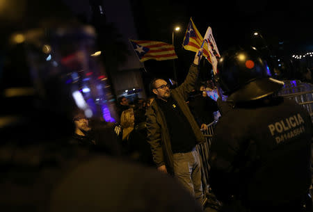 A man holds up flags during a protest against Spanish Prime Minister Pedro Sanchez outside a hotel in Barcelona, Spain, December 20, 2018. REUTERS/Susana Vera
