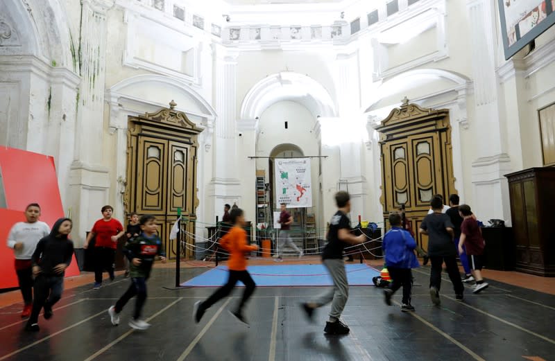 Children run around a boxing ring at the Santa Maria della Sanita Basilica in the Rione Sanita neighbourhood in Naples