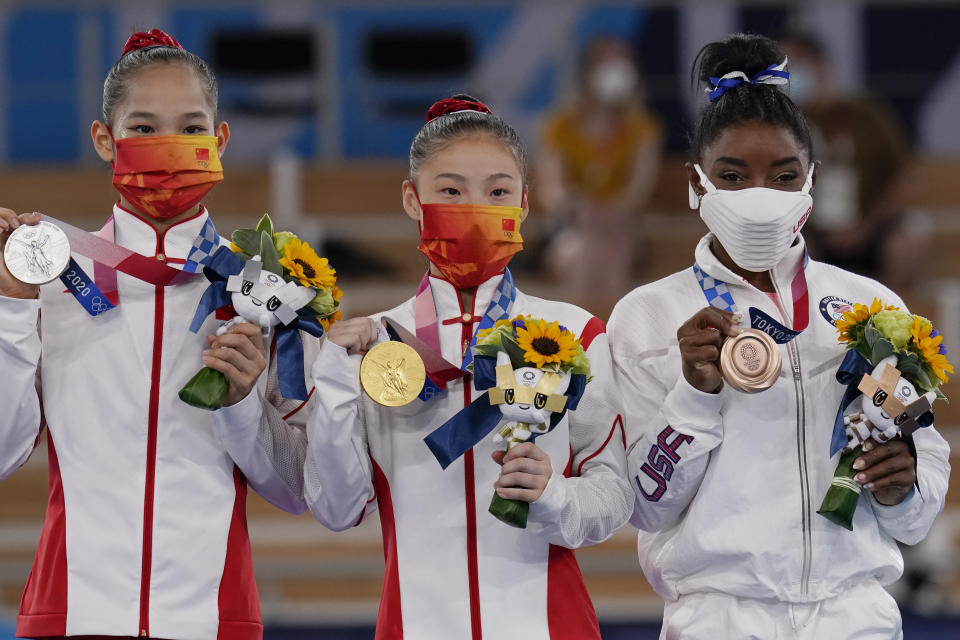 Gold medalist Guan Chenchen, of China, center, stands on the podium with silver medalist Tang Xijing, of China, left, and bronze medalist Simone Biles, of the United States, after balance beam competition during the artistic gymnastics women’s apparatus final at the 2020 Summer Olympics, Tuesday, Aug. 3, 2021, in Tokyo, Japan. (AP Photo/Gregory Bull) - Credit: AP