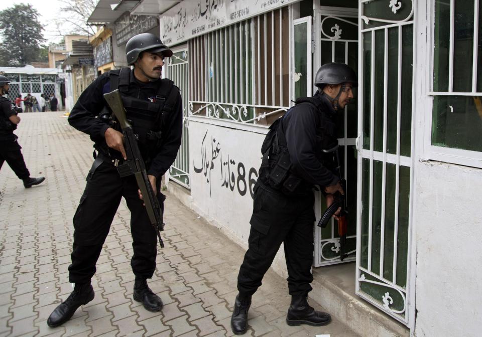 Pakistani police commandos search inside lawyers offices looking for attackers following a suicide attack in a court complex, in Islamabad, Pakistan, Monday, March 3, 2014. Two suicide bombers blew themselves up at a court complex in the Pakistani capital on Monday, killing nearly a dozen and wounding scores in a rare terror attack in the heart of Islamabad, officials said. (AP Photo/B.K. Bangash)