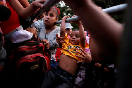 People belonging to a caravan of migrants from El Salvador en route to the United States, board a pick-up truck for a hitchhike along the highway to Ciudad Tecun Uman, Guatemala from Moyuta, Guatemala, November 1, 2018. REUTERS/Jose Cabezas/File photo