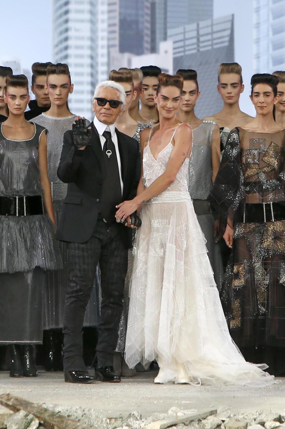 German fashion designer Karl Lagerfeld, foreground centre left, surrounded by models, acknowledges applause following the presentation of the Haute Couture Fall-Winter 2013-2014 collection he designed for Chanel, Tuesday, July 2, 2013 in Paris. (AP Photo/Francois Mori)