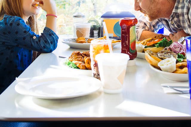 <p>Getty</p> A man and a child eating at a restaurant (stock image)