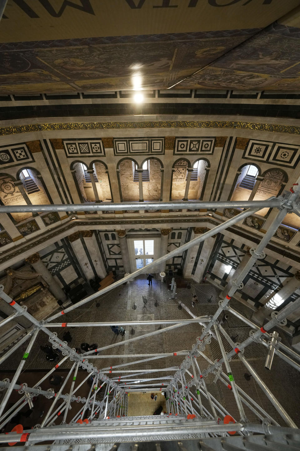 Visitors admire St. John's Baptistery, one of the oldest churches in Florence, central Italy, Tuesday, Feb. 7, 2023. The Baptistery's dome is undergoing a restoration work that will be done from an innovative scaffolding shaped like a giant mushroom that will stand for the next six years in the center of the church, and that will be open to visitors allowing them for the first and perhaps only time, to come come face to face with more than 1,000 square meters of precious mosaics covering the dome. (AP Photo/Andrew Medichini)