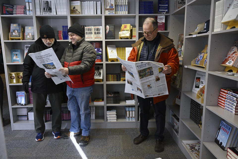 FILE - Andy Thibault, Editor and Publisher of The Winsted Citizen, left, looks over the papers first issue with town planner Lance Hansen, center, as Winsted economic development director Ted Shafer, right, looks over his own copy, Friday, Feb. 3, 2023, in Winsted, Conn. American Business Media said Wednesday that it has acquired the Winsted Citizen, whose oversight board had decided only two days earlier that it could no longer operate because of financial woes. Terms were not disclosed. (AP Photo/Jessica Hill, File)