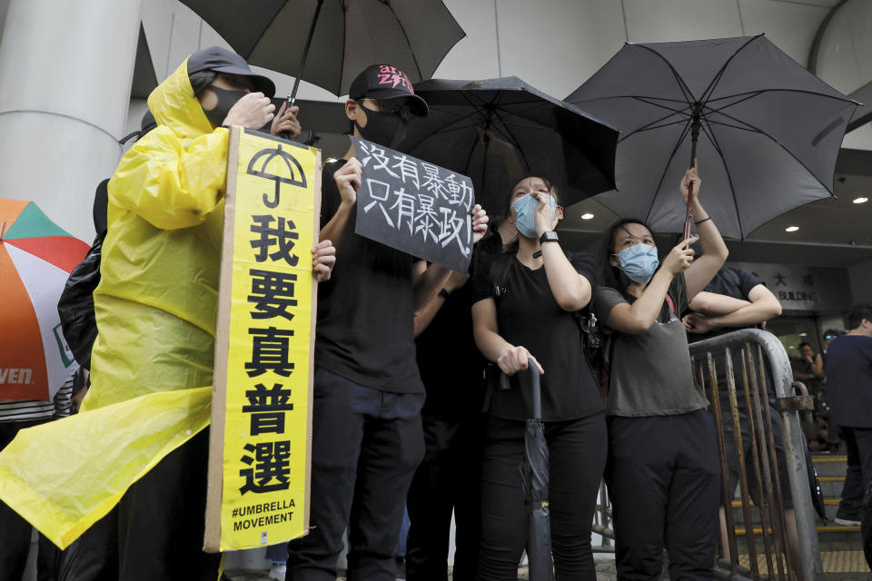 Protesters hold placards that read: "I want real elections" and "No thug, only tyranny" as they gather outside the Eastern Court in Hong Kong, Wednesday, July 31, 2019. Supporters rallied outside a court in Hong Kong on Wednesday ahead of a court appearance by more than 40 fellow protesters who have been charged with rioting. (AP Photo/Vincent Yu)