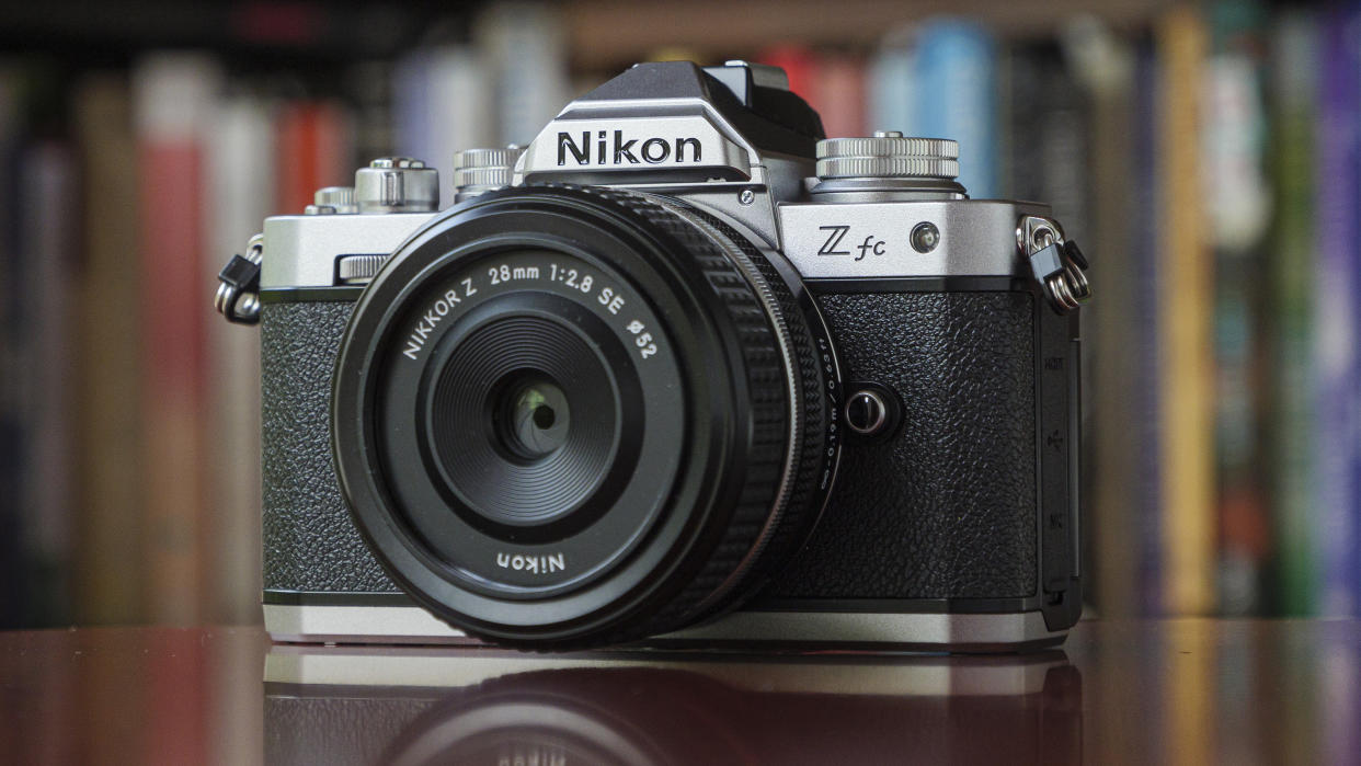  The Nikon Zfc camera on a red table in front of a bookcase. 