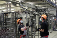 Workers assemble frames for hospital beds at the Linet factory in Slany, Czech Republic, Monday, Oct. 19, 2020. A Czech hospital bed maker with a full order book received one more order that was impossible to turn down. The company was approached by Prime Minister Andrej Babis to deliver beds for a military field hospital for 500 COVID-19 patients, to be built this week in Prague. (AP Photo/Petr David Josek)