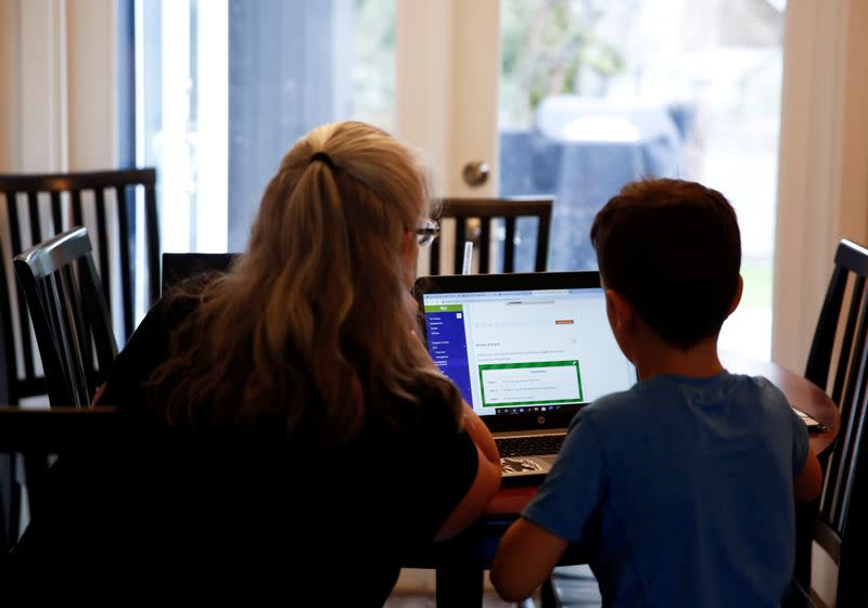 FILE PHOTO: Miller, a 4th grader at Cottage Lake Elementary, works with his grandmother Brackett as they try to figure out how to navigate the online learning system the Northshore School District will use for two weeks due to coronavirus concerns, at Brackett's home