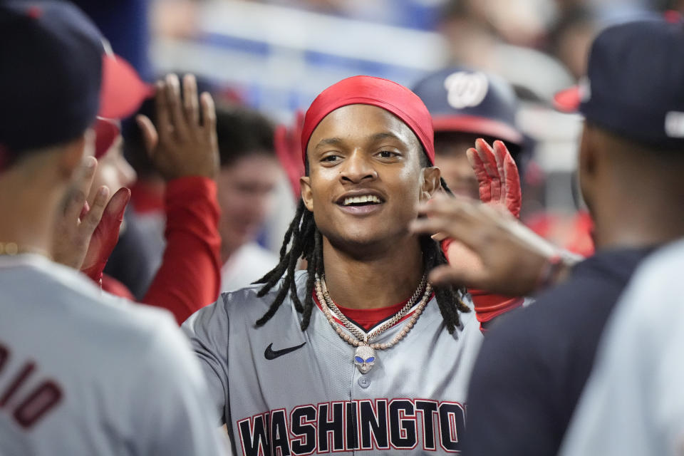 Washington Nationals' CJ Abrams is congratulated by teammates after he and Trey Lipscomb scored on a single by Joey Meneses during the eighth inning of a baseball game against the Miami Marlins, Friday, April 26, 2024, in Miami. (AP Photo/Wilfredo Lee)