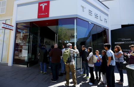 People wait in line at a Tesla Motors dealership to place deposits on the electric car company's mid-priced Model 3 in La Jolla, California March 31, 2016. REUTERS/Mike Blake