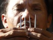 �Ruben Enaje, 52, who will portray as Jesus Christ for the 27th time, shows three-inch nail which he will use on a Good Friday crucifixion re-enactment in San Pedro Cutud town, Pampanga province, north of Manila. The Roman Catholic church frowns on the gory spectacle held in the Philippine village of Cutud every Good Friday but that does nothing to deter the faithful from emulating the suffering of Christ and taking a painful route to penitence.