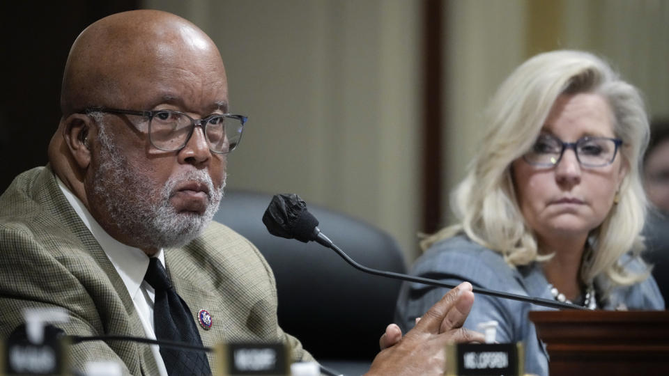 Rep. Bennie Thompson at the microphone, looking stern, as Rep. Liz Cheney looks on.