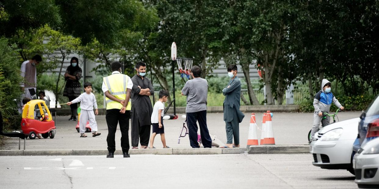 People believed to have recently arrived from Afghanistan stand in the courtyard of a hotel near Manchester Airport on August 25, 2021 in Manchester, England.