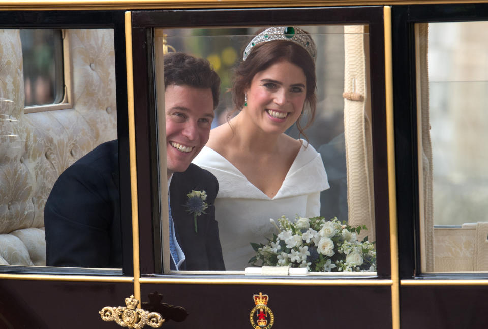 Princess Eugenie of York and Jack Brooksbank wave to the crowds from their carriage following their wedding ceremony at St. George's Chapel in Windsor Castle on October 12, 2018