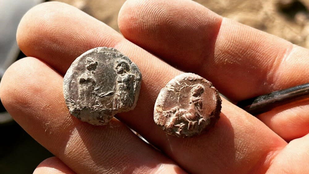  A person holds clay seals in their hand. 
