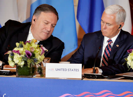 FILE PHOTO: U.S. Secretary of State Mike Pompeo (L) leans in as Vice President Mike Pence makes a note during the Second Conference on Prosperity and Security in Central America, which includes Mexico, Guatemala, Honduras and El Salvador, at the State Department, in Washington, U.S., October 11, 2018. REUTERS/Mike Theiler/File Photo