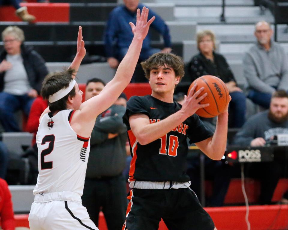 Hudson's Ambrose Horwath looks to pass while defended by Clinton's Ryan Tschirhart.