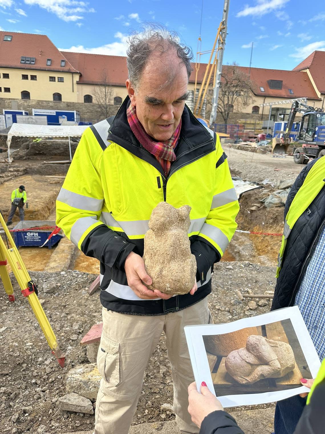 An archaeologist holds the “giant” carving that was part of a Jupiter column in Stuttgart.