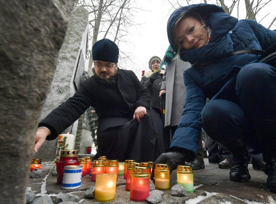 <p>Members of the Minsk, Belarus Jewish community light candles at the Minsk Ghetto Victims Memorial in a former Jewish cemetery on the eve of Holocaust Memorial Day, Jan. 26, 2018. (Photo: Viktor Drachev/TASS via Getty Images) </p>