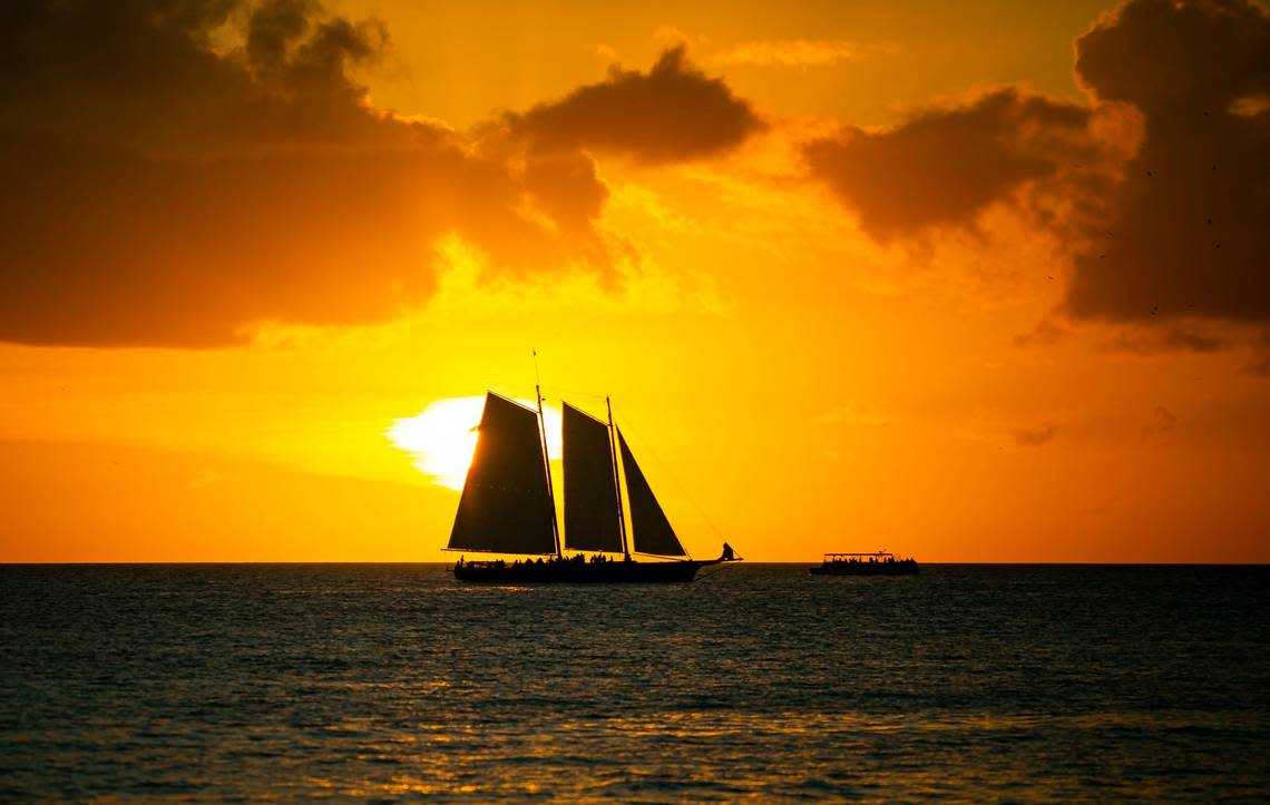 The sun sets over a sailboat near Key West, Florida on Saturday, December 11, 2021.