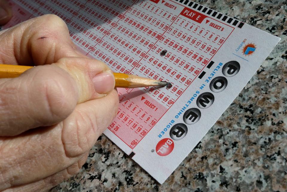 A lottery player fills out choices  on a Powerball form.