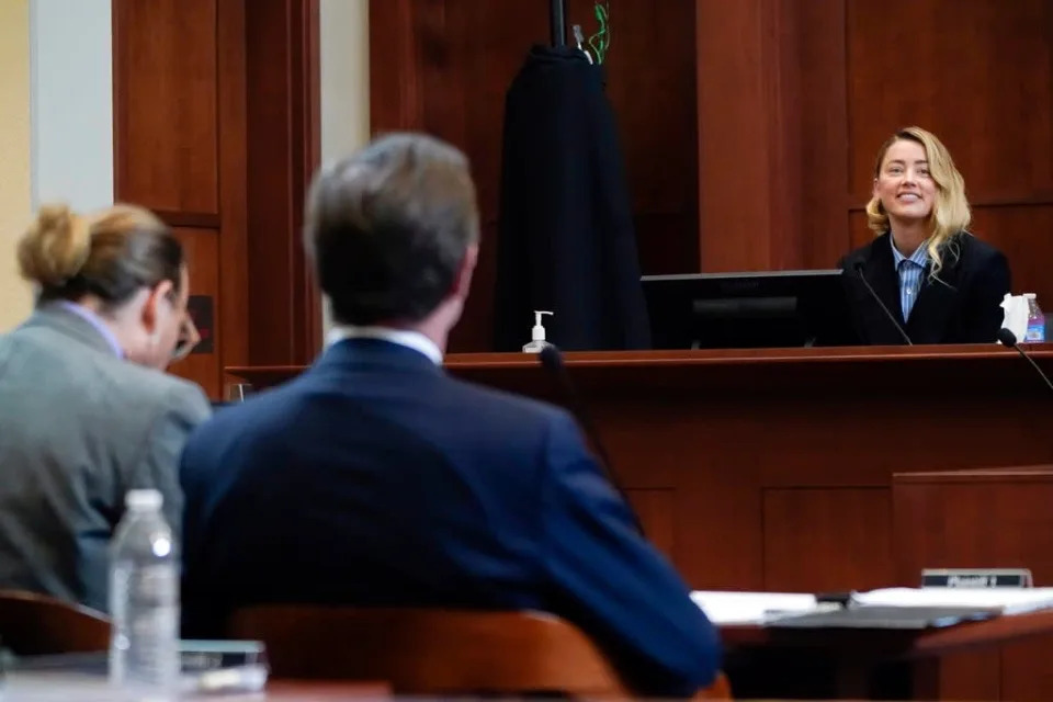 Amber Heard testifica mientras Johnny Depp, a la izquierda, escucha, en el Tribunal de Circuito del Condado de Fairfax, el miércoles 4 de mayo de 2022 (AP)