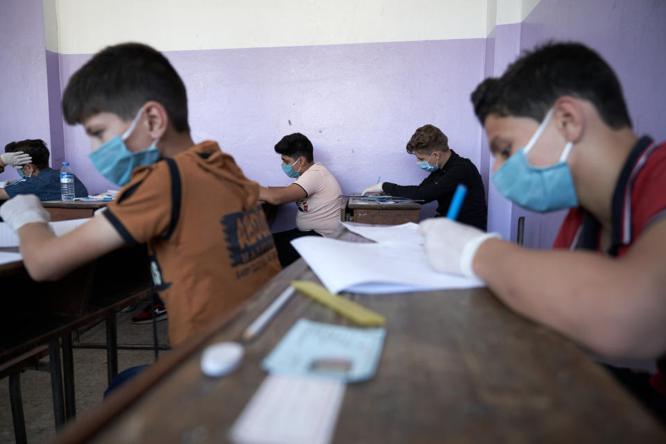 Syrian students in Idlib province take the middle school exam while maintaining safety procedures on July 12.