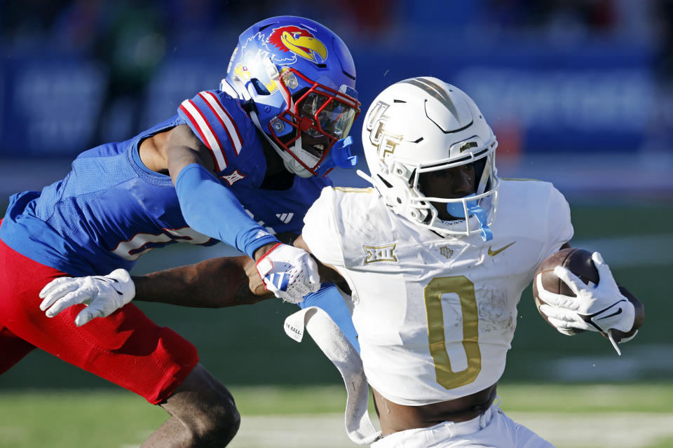 Kansas cornerback Cobee Bryant, left, stops Central Florida running back Johnny Richardson (0) during the second half of an NCAA college football game Saturday, Oct. 7, 2023, in Lawrence, Kan. (AP Photo/Colin E. Braley)