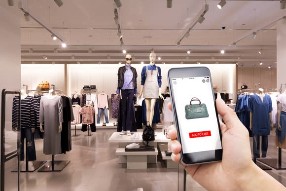 A shopper checks a handbag's price on a smartphone app.