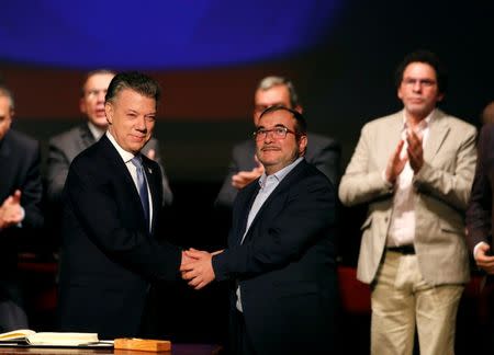 FILE PHOTO: Colombia's President Juan Manuel Santos and Marxist FARC rebel leader Rodrigo Londono, known as Timochenko, shake hands after signing a peace accord in Bogota, Colombia November 24, 2016. REUTERS/Jaime Saldarriaga